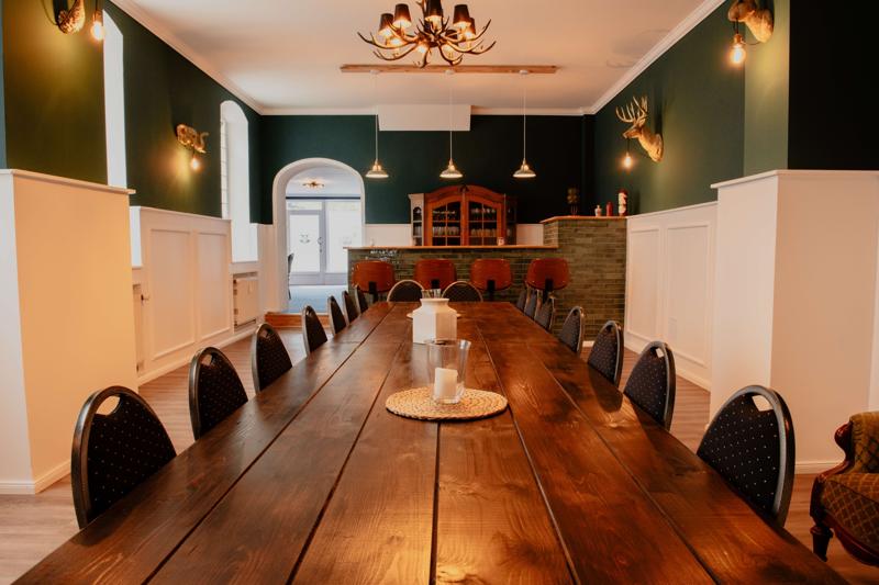 Großer Tisch in rustikalem Raum mit Geweihleuchten